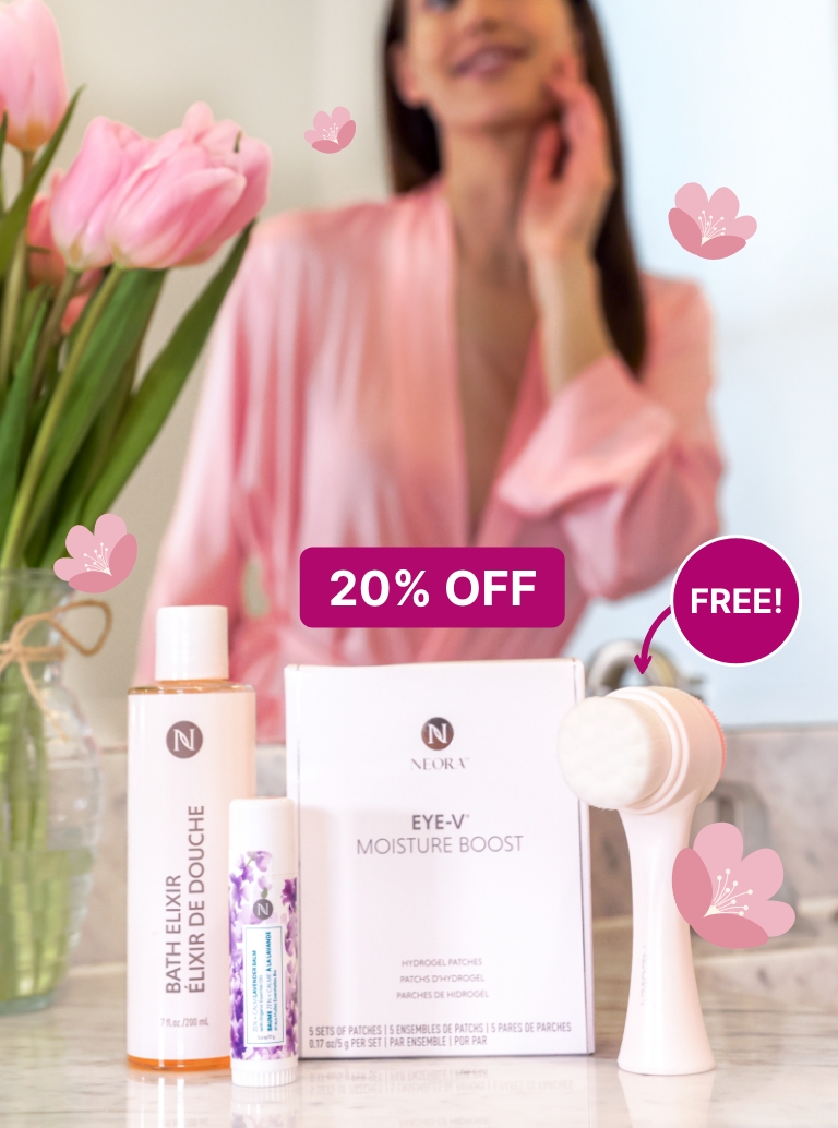 Alt text: Woman holding Neora’s Make Her Mother’s Day Bundle which includes: Zen + Calm Lavender Balm, Bath Elixir, Eye-V Moisture Boost Hydrogel Patches and a FREE dual-sided Facial Scrubber